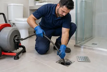 Profissional desentupindo um ralo em Itabaiana com equipamentos especializados.